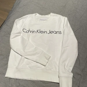 Sweatshirt Calvin Klein Jeans - Vit ngt croppad sweatshirt från Calvin Klein. Fint skick