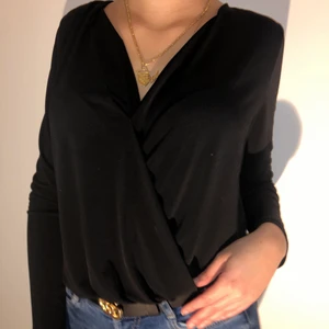 Svart body blus  - Fin elegant svart blus (det är en body) den går omlott, brukar ha säkerhetsnål då den är ganska v ringad, det är st xs
