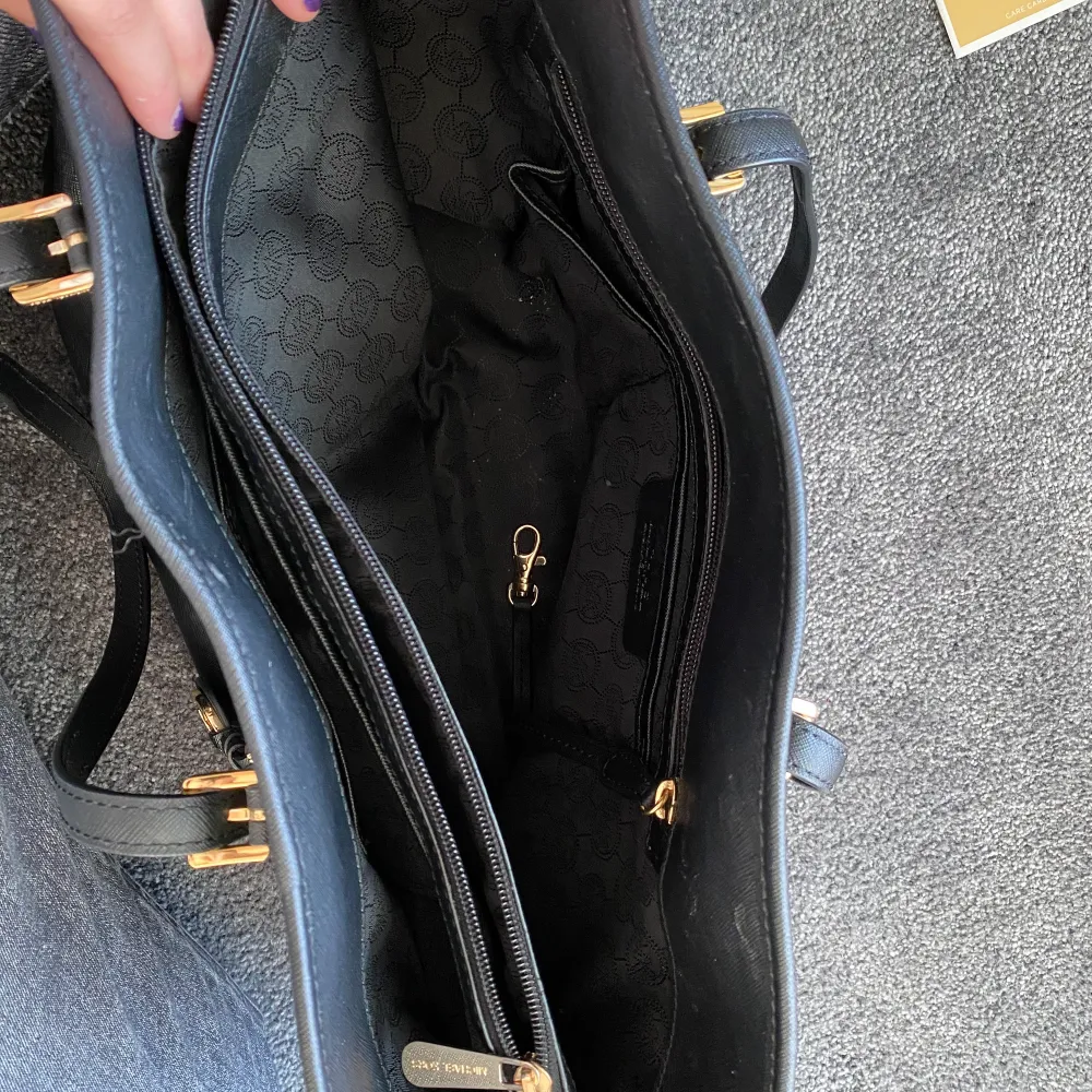 Stor svart micheal kors väska med guld detaljer. Perfekt som skolväska eller jobbväska - datorn + böcker får plats! Den har olika bra fack för allt man kan tänka sig. Medgår band som hör till väskan om man vill ha den som en overcrossbag - dem är reglerbara. Passar till allt. 100% äkta har dustbag + äktskapsbevis som syns på bilden. Nypris: ca 3500kr. Laukut & Käsilaukut.