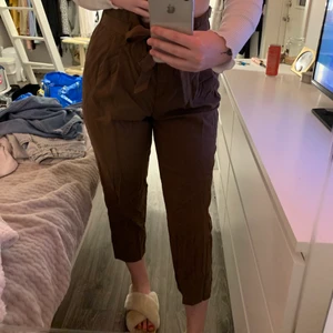 Bruna kostymbyxor  - Jättefina och höstiga kostymbyxor från hm, aldrig använda! De ser väldigt pösiga ut på bilderna, men det är endast för att de är alldeles för stora på mig. Jag är 170 cm lång och de är alldeles för korta för mig, tror de hade passat någon bra mycket kortare än mig bättre. Strl 42🤎