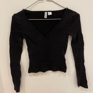 Söt topp - Säljer denna super söta top från H&M då den är för liten. Använd en gång så den är nästan i nyskick🥰 Den har en liten urringning och går omlott över bröstet🌸