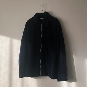 Our Legacy Drip Shirt Glow Navy Corduroy - Our Legacy Drip Shirt, modell Glow Navy Corduroy. Inköpt för runt två år sedan och har det senaste året endast hängt i garderoben. Säljes pga att den är lite för liten (jag är 190 cm lång). I gott skick men med lite slitage på baksidan nedanför kragen, vilket syns i bild 3. Säljer den för 800 kr (sänkt från 1000 kr) som utgångspris men kan tänka mig att gå ned något vid snabb affär.