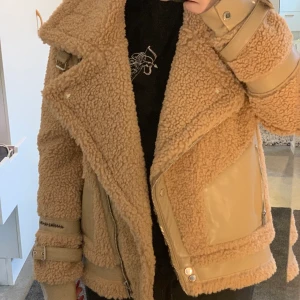 Helt ny Beige teddy bikerjacka med lapp - Beige varm teddy jacka i biker modell från maniere de voir. Ganska oversized, i storlek 10, vilket mostsvarar 38 men passar en i storlek 40-42 också beroende på hur man vill att den ska sitta. Nypris ca 1000kr 