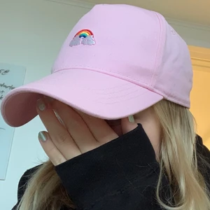 💕 rosa keps med regnbågsmotiv 💕 - Knappt använd keps från Monki! Babyrosa med en liten regnbåge på framsidan. ONESIZE och går att justera passformen bak till 🥰