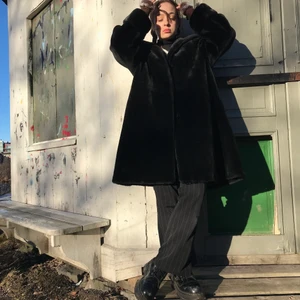 Svart rock i fejkpäls - Supergosig pälsjacka (fejk) som är varm och har en söt luva och stora fickor✨ den har ett litet brännmärke på ena armen som varit där sen jag köpte den, syns inte så mycket men säljer den billigt pga det! 