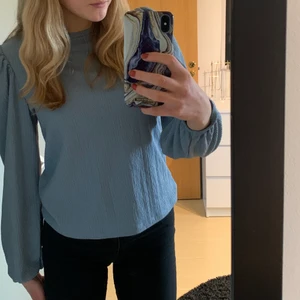 Ljusblå blus  - Jättefin ljusblå blus från NA-KD. Helt oanvänd med prislappen kvar, jag säljer den då den inte kommit till användning. Storlek S med puffärmar och en mudd nere vid armen. Perfekt vårtröja som går att styla upp eller styla ner💙 Säljer den för 150kr + frakten som ligger på 66kr.💙