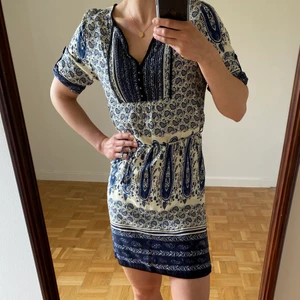 Blåmönstrad sommarklänning, stlk S - Sval bomullsklänning i underbart blått mönster 😍🫐 Köpt i Grekland för några år sedan. Stlk S. Snöre i midjan, små knappar mitt på bröstet, möjlighet att ha ärmanarna ner till armbågarna om man inte vill ha dem uppfästa. Skickar gärna fler bilder🌼