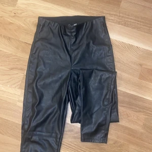 Svarta läder tights - Svarta tights/byxor i läder med resårmidja. Storlek 34. Använda 1 gång!