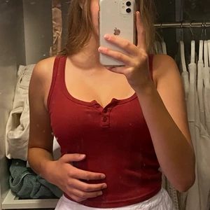 Röd topp - Brandy Melville topp i en vinröd färg som jag köpte för något år sedan i London. Väldigt snygg som går att knäppa upp mer eller mindre. Frakt ingår i priset! 🤍