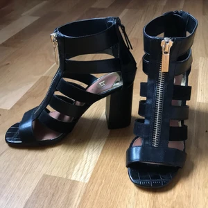 Bekväma sandaler med klack - Nyskick - Sandaler med bred klack från River Island som är stabila och lätta att gå i. Prydnadsdragkedja i fram och funktionell dragkedja i hälen. 