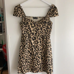 Leopardmönstrad klänning från PLT - Leopardmönstrad klänning. Stabilt material med guldknappar. Använd 2-4 gånger. Rekommenderas till någon med liten byst. 