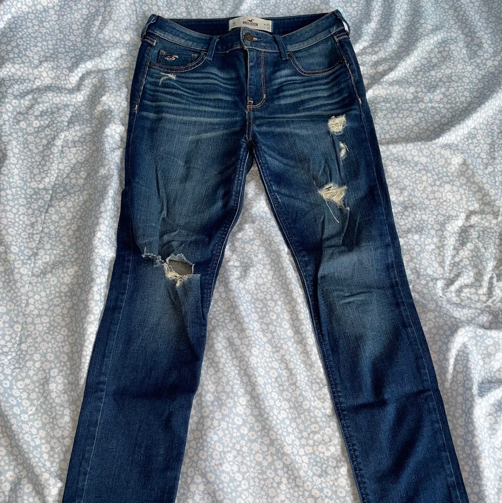 Mörkblå Hollister jeans med slitningar, storlek 25/31, i fint skick. . Jeans & Byxor.