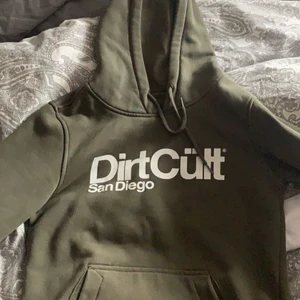 Dirtcult hoddie  - En grön dirtcult hoddie köpt för mindre än ett år sen, använda ca 2 ggr så i väldigt bra skick, dock en liten fettfläck under trycket (se bild 2) men den syns knappt, annars inget fel på den, Strl S men passar Xs också, nypris 599kr mitt pris 250+ frakt på 79kr🤍