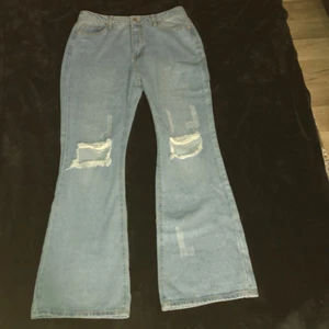 Utsvängda jeans med hål på knäna, M/L - Helt oanvänd. Storlek M men psssar som L också. Jeansen är från Ginatricot. Men pris kan diskuteras också. 