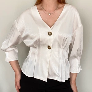 Tjusig blus som passar alla - Vit blus med trekvartslånga ärmar med två knappt framtill • tyget är blankt och härligt och modellen gör att den sitter fint på många storlekar • från Vero Moda i storlek M • använt ett fåtal gånger • frakt på 48kr tillkommer :) 