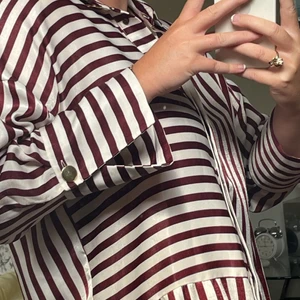 Randig klänning  - Vit och vinröd klänning i lite glansigt tyg från Zara. Lite oversized. 