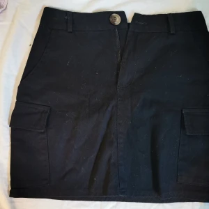 Kjol  - Sitter fint på, har fickor framme och på sidorna 