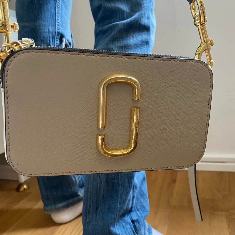 Säljer min favoritväska från Marc Jacobs. Modellen är Camera Snapshot Bag och nypris är 3400kr🥰den sparsamt använd och skicket är mycket bra förutom att ena facket har lite fläckar i sig från en bronzer. Kontakta för mer bilder❤️bandet är även justerbart. Väskor.