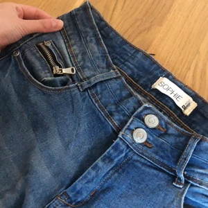Blåa Gina Tricot-jeans  - Skitsnygga blå Gina-jeans som såldes för många år sen! Knappt använda så i bra skick, medelhög midja och sitter verkligen prima på kroppen! Framhäver ens former!! Stretchigt och skönt material och snygga detaljer på fickorna fram och bak och dubbla knappar. 