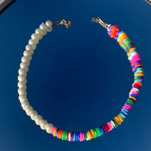 Ett halsband med hälften färgglatt och hälften vita pärlor som jag gjort! Säljer!🌿🌱🍃✨🌱💐🌺