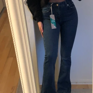 Jeans - Oanvända bootcut jeans med prislappen på. Lågmidjade, exakt vid naveln. Snygg mörkblå färg!! 