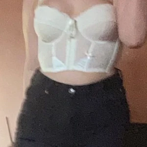 Bralette med bygel - En vit och ljusrosa trendig bralette med bygel som man knäpper på framsidan som ni ser på andra bilden. Justerbara band och använd ca 3 gånger. Ingen push up men man får ändå fina bröst. Man kan även knyta en rosette över brösten.