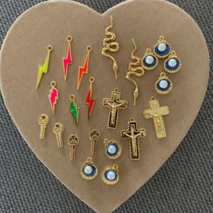 charms  - massa olika 14/18/24 k guld platerade charms som man kan göra halsband, armband och örhängen av!  - blixt: 20kr styck. -orm: 25kr styck -kors: 30kr styck -snäcka: 20kr styck -nyckel: 15kr styck! Kan även göra dom till halsband och armband efter förfrågan! Halsband: 70kr armband: 65kr 