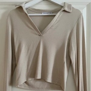 Ribbad tröja  - En ribbad tight tröja i en beige färg med en v-ringning samt krage! Den är ifrån strandivarius och är i storlek M😛