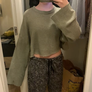 Croppad stickat  - En fin grön stickad tröja som jag själv har klippt av. Den är köpt på lager 157. Fin med stora armar som fladdrar. Stretch!! Har en lite svart fläck på armen som man ser på en av bilderna men inte man tänker på annars. Frakten är inkluderad i priset. 