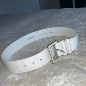 Vitt skärp (märket är saddler) - Hej säljer nu detta fina vita skärpet som är från saddler. Jag har tyvärr växit ur skärpet så därför säljs det. Längden är 65cm så passar XS skulle jag säga. Tar endast swisch, Kontakta för mer info!💖
