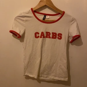 Tröja -  Det är röd på feet kanterna är röda och texten i röda men båten är vit Texten är det CARBS