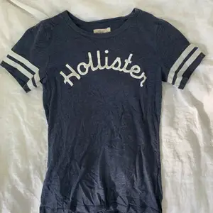 En väl använd Hollister T-shirt i storlek S. Den är i fint skick på sättet att det är inga lösa sömmar, hål etc. Däremot nopprig och lite ”skavd” på Hollister texten i fram. Köparen står för frakten