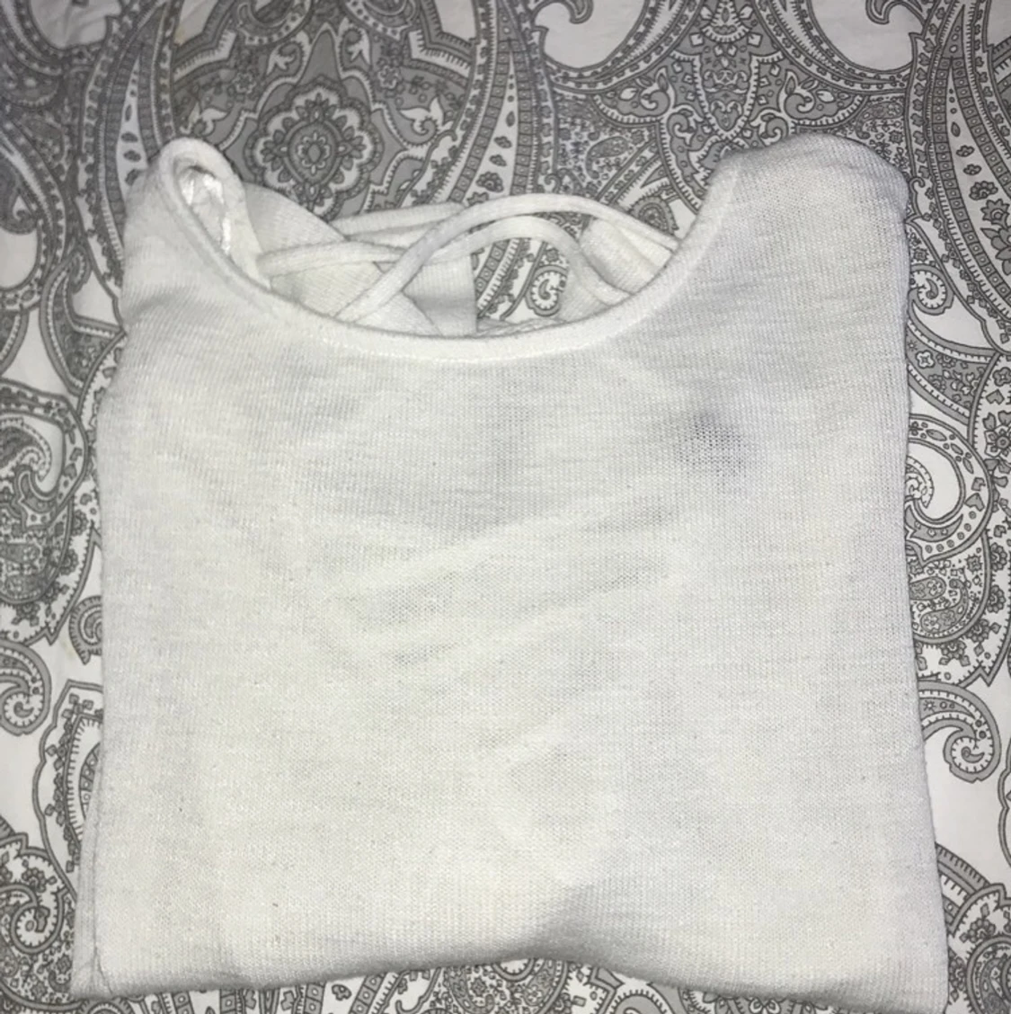 En vit (mer genomskinlig) stickad långärmad tröja. Används max 3 gånger. Den kommer ifrån H&M. Storlek M, lite liten i storleken. Har en snörning bak i nacken. - 90