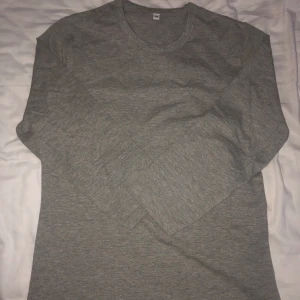 Tröja - En grå tröja med en normal krage, lite kortare armar. Tröjan är tajt och bara testad!!