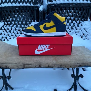 Nike Dunk High Michigan 42 - Hej, säljer ett par höga dunks i färgen Michigan storlek EU 42 / US 8,5. Köpta 2020 men helt nya och oanvända i sin låda med tillbehör samt kvitto. Perfekt nu inför våren med ett par nya och fräscha sneakers på uteserveringen! Möts upp eller skickas dubbelboxad mot fraktkostnad. Har inte bråttom med att sälja men prutmån finns vid smidig affär. Väl mött!