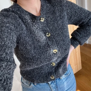 Mörkgrå kofta med ballongärm - Jättefin mörkgrå kofta med knappar fram. Lite kortare i modellen och med lite ballongärm. Knappt använd så bra skick 🌟 passar XS-S. Skriv för fler bilder!
