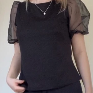 Svart topp - En jättefin svart puffärms topp från märket vila! Endast testad och har prislappen kvar! Köpt för 299kr Inga defekter förutom något litet hål på baksidan av ärmen (se bild 3) verkligen inget som man tänker på🥰