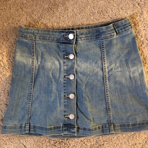 Cubus jeanskjol med knappar - Jeanskjol storlek XS från Cubus, använd kanske 5 gånger. Sitter tajt i midjan men i övrigt inte jättetajt. 