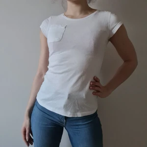 Vit T-shirt med bröstficka - Vitt T-shirt med bröstficka. Storleken syns rj med skulle tippa på XS.