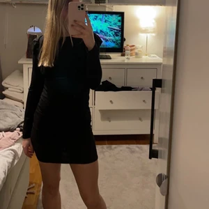 Klänning - Svart klänning med volang, sitter väldigt snyggt 