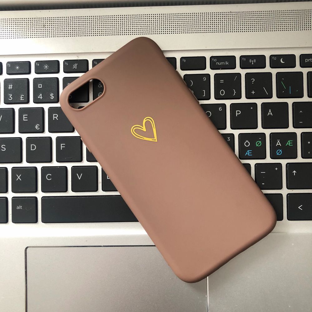 Säljer ett helt nytt mobilskal till en iPhone 6/7/8💘 || Skalet är i en mörkare beige färg med ett guldigt hjärta på || Osäker på vilket material det är i, men liknar plats fast det är mjukare (böjbart)✨ || Köparen står för fraktkostnaden på 12kr📦. Accessoarer.