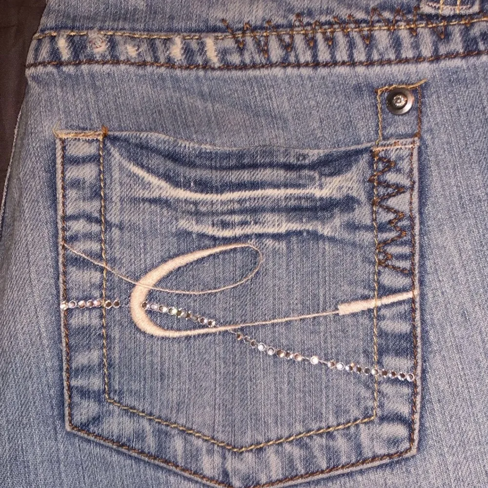 Vintage lågmidjade bootcut jeans i storlek 34, köpta för ungefär 20 år sedan men väldigt bra skick. Lite slitna längst ner. Fina glittriga detaljer på backfickorna och knappar. Buda i kommentarerna eller i chatten från 100 kr. . Jeans & Byxor.