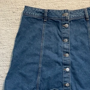 Jeanskjol - En jeanskjol med knappar framtill från H&M. Storlek:  42