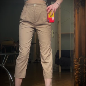 Beiga Chinos strl 34 - Använda ett fåtal gånger. Färg matchar bäst första bilden. Finns 2 extra knappar. Jag är 170cm lång och de slutar kring vaderna. Kan mötas upp i Malmö och Lund. Pris kan alltid diskuteras! 🦁