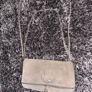 Zadig & Voltaire  - Modell: Rock Suede Clutch.                                 Färg: Bleu de gris.                                               Nypris: 3200 kr , två avtagbara band medföljer ( olika längder).                                                  Erbjuder fler bilder på väskan om man vill:)