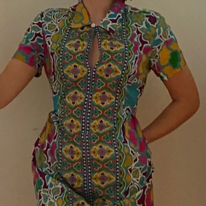 Klänning - En fin klänning i nyskick som inte kommer till användning. Storlek S men passar kanske M också. Slutar ovanför knäna. Lätt, luftigt och skönt material och fin passform. 100% viskos. Man kan knäppa en knapp längst upp vid kragen om man vill, eller så kan man ha den öppen. Skriv privat vid funderingar. Köpt på Indiska. Kan mötas i Umeå eller skicka om köpare står för frakt. 