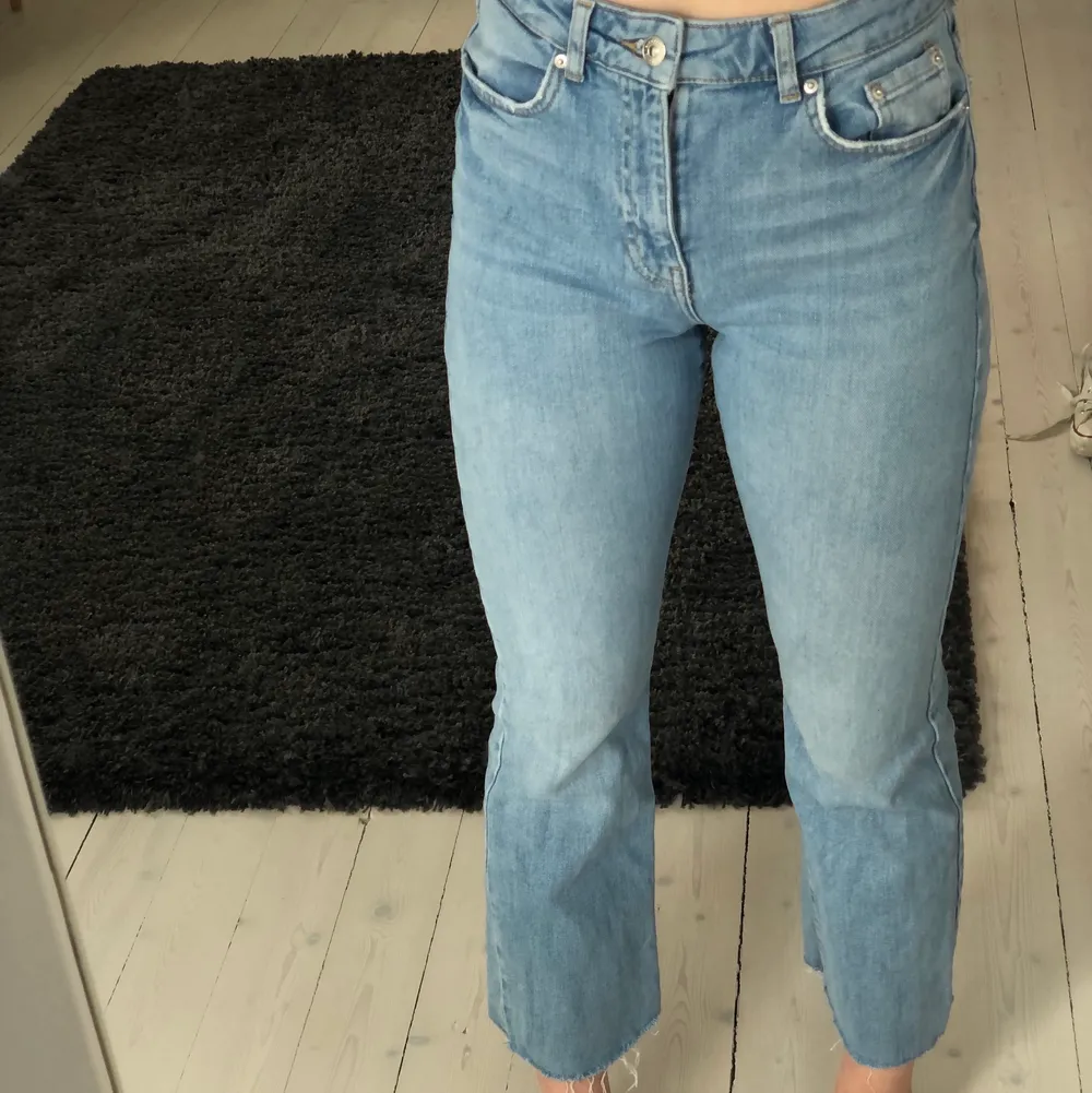 Ett par blåa jeans som går ner till anklarna. Storlek: 36. Jeans & Byxor.