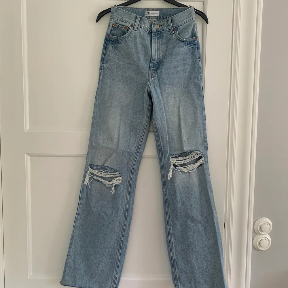 Nya jeans från zara med vida ben och slitningar på knäna i storlek 34. Endast använda 1 gång så jeansen är i nyskick.    Köparen står för frakt!😊. Jeans & Byxor.