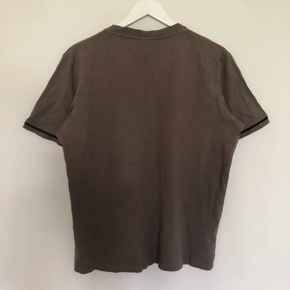 En vintage nike t-shirt med en mini swoosh. Tröjan är i populär brun färg som under den senaste blivit väldigt trendig. Tishan har 5 streck som går över den. Den är i vintage skick och har inga defekter. Storlek Large.. T-shirts.