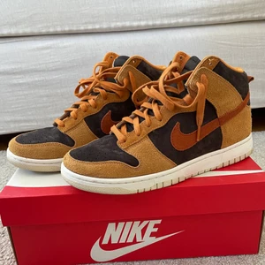 Nike Dunk High Russet - Säljer mina Nike dunk high russet som är använda mindre än 10 gånger. Condition 9/10. Väldigt fin mocka på skon. Storlek 44. Buda eller föreslå trades.